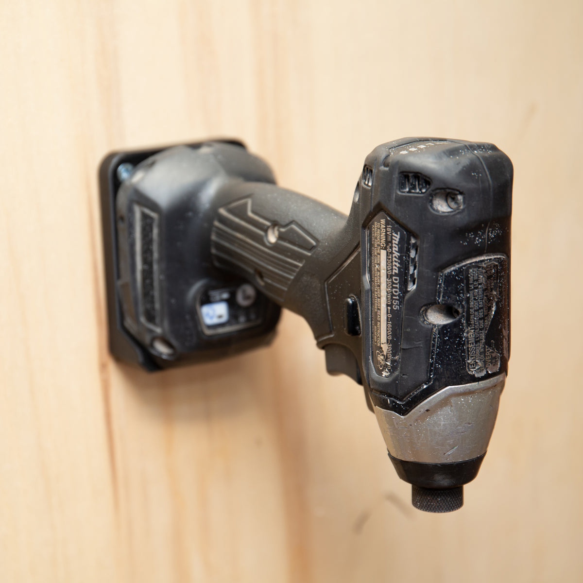 Makita 18V impact driver hanging on a 3D printed wall mount